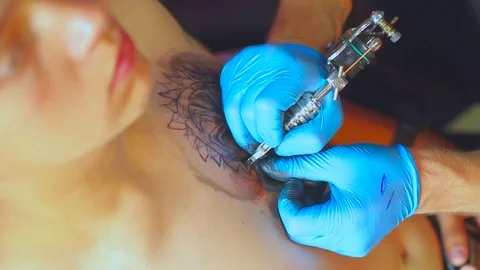 The tattoo artist does the tattoo Vidéo 77384124