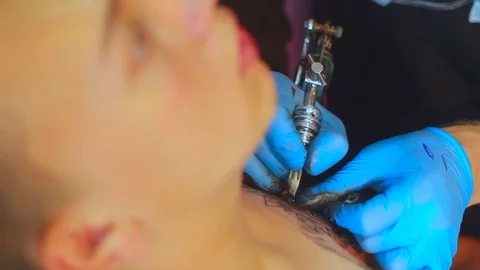 The tattoo artist does the tattoo Stockbeeldmateriaal 77384891