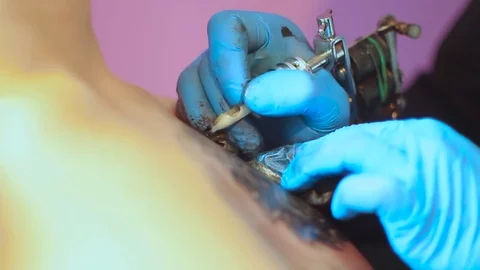 The tattoo artist does the tattoo Stock Footage 77388341