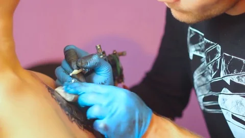 The tattoo artist does the tattoo Stock Footage 77394311