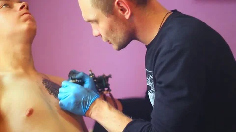 The tattoo artist does the tattoo Stock Footage 77750546