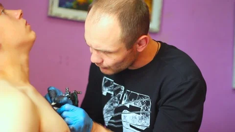The tattoo artist does the tattoo Stock Footage 77750615