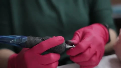 Tattoo artist inserts a new needle into the machine Stock Footage 151258266