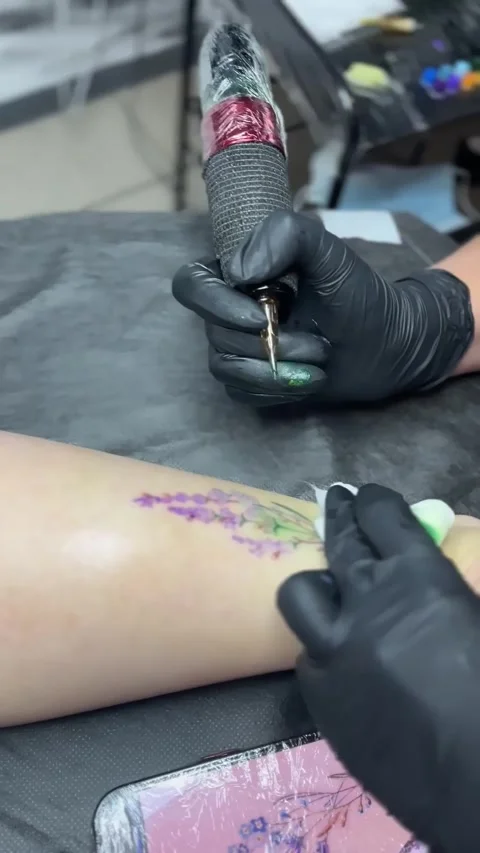 Tattoo artist makes a tattoo to a client Stock Footage 249792452