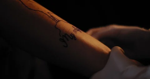 Tattoo artist preparing a drawing on a person's hand for tattooing. BMPCC 4K Stock Footage 125764663