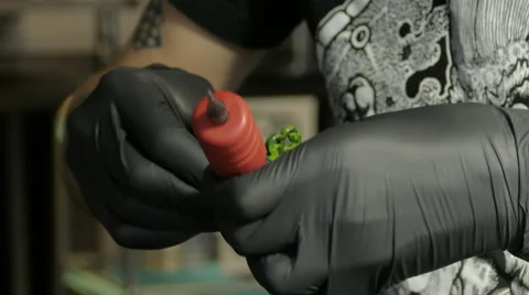 Tattoo artist setting up machine, 4k Stock Footage 63301668