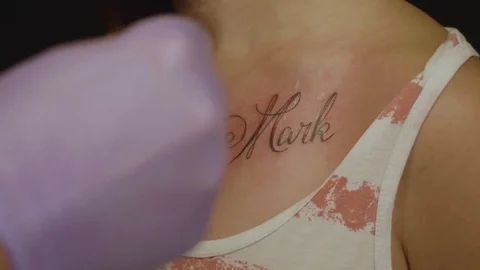 Tattoo artist sticks plaster to part of skin with finished tattoo Stock Footage