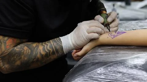 Tattoo artist tattooing client Stock Photos