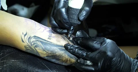 Tattoo machine. creating picture on hand with it in salon Stock Footage 139707767