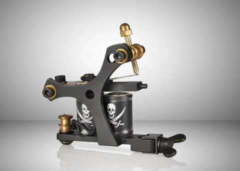 Tattoo machine over gray background Stock Photos