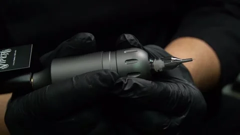 Tattoo machine. tattoo artist inserts the game. tattoo parlor Stock Footage 232046383