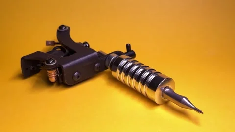 Tattoo Machine on Yellow Background Vídeo Stock 303381878