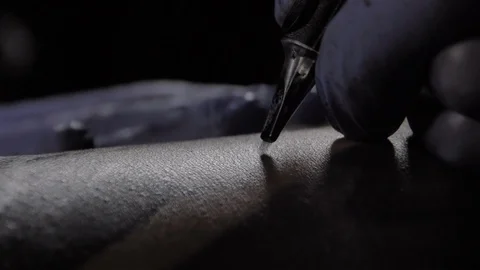 Tattoo master in blue gloves makes a tattoo, macro shot, slowmotion Stock Footage 129320728