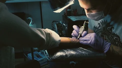 Tattoo master does tattoo on hand Stock Footage 73173221
