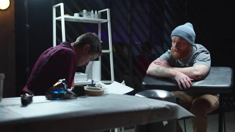 Tattoo master draws a sketch, the client is waiting Stock Footage 131038544