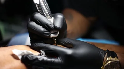 Tattoo master hands busy with work at tattoo salon. Close up. Video stock 166166410