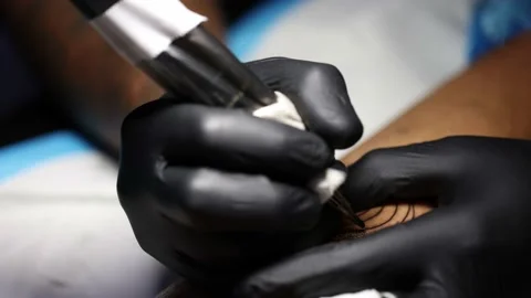 Tattoo master hands busy with work at tattoo salon. Close up. Video stock 166556412