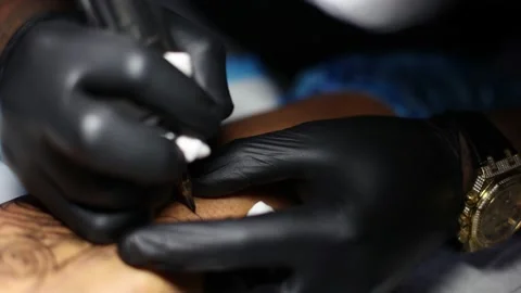 Tattoo master hands busy with work at tattoo salon. Close up. Video stock 183989551