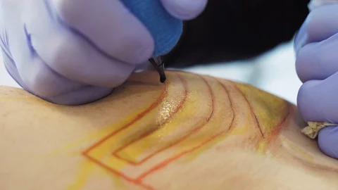Tattoo master makes a tattoo on his hand client Stock Footage 122294375
