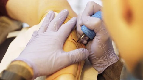 Tattoo master makes a tattoo on his hand client Stock Footage 122335682