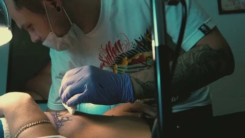 Tattoo master makes the tattoo on a woman's body close-up Stock Footage 73146397
