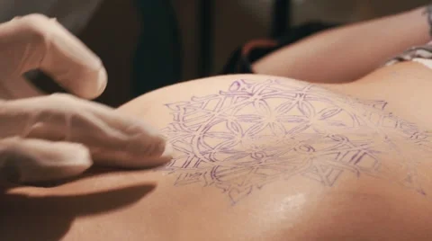 Tattoo master making a tattoo of mandala pattern. Close up shot of hands Stock Footage 67514169