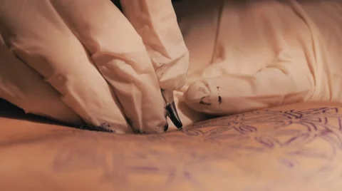 Tattoo master making a tattoo of mandala pattern. Close up shot of hands Stock Footage 67514912