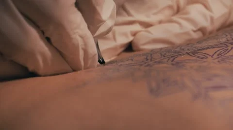 Tattoo master making a tattoo of mandala pattern. Close up shot of hands Stock Footage 67515107
