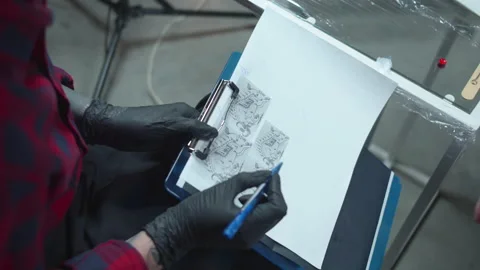 Tattoo master shows the client sketches. Sliding Stock Footage 131038217