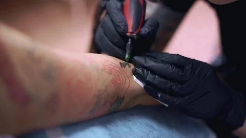 A tattoo master tattooing a female hand Stock Footage