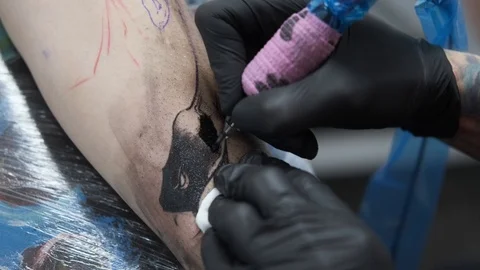 Tattoo Studio, guy gets color tattoo on his arm, it's bleeding Stock Footage 127551034