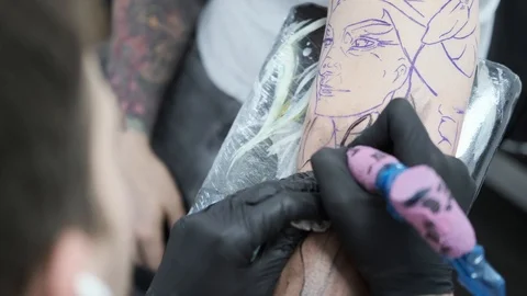 Tattoo Studio, guy gets color tattoo on his arm, it's bleeding Stock Footage 127551122