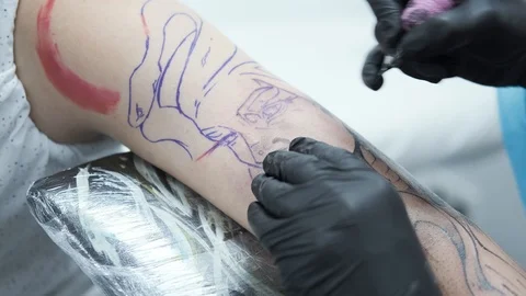 Tattoo Studio, guy gets color tattoo on his arm, it's bleeding Stock Footage 127551348