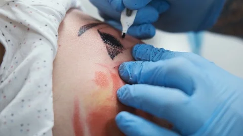 Tattoo Studio, guy gets color tattoo on his arm, it's bleeding Stock Footage 127551635