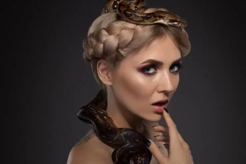 Tattooed blonde with python on black background Photos
