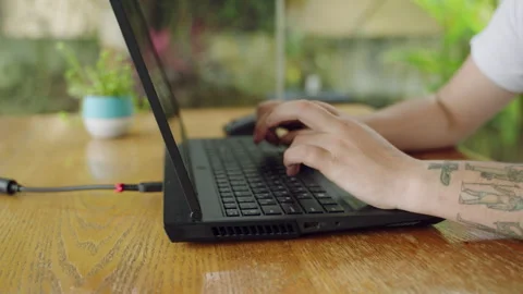 Tattooed developer types code on laptop, tech work in progress. Programming Stock Footage 268727606