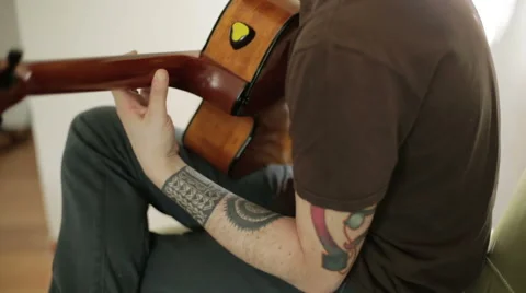 A tattooed guy playing the guitar Stock Footage 61898594