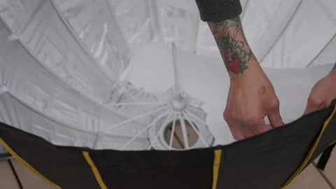 Tattooed hand snapping in diffuser for parabolic soft box Stock Footage 174892573