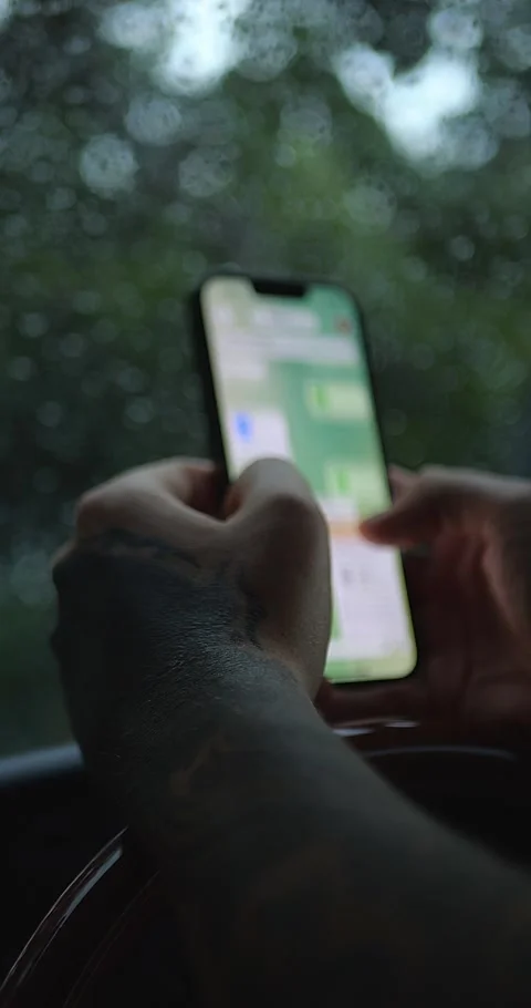 Tattooed Hand Using or Holding Smartphone By Rain-Covered... Stock-Footage 332075637