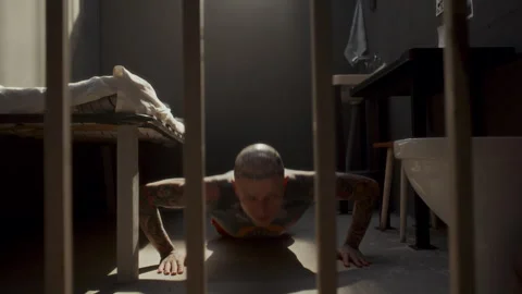 Tattooed Inmate Exercising in Prison Cell by Doing Pushups Stock Footage 310337613