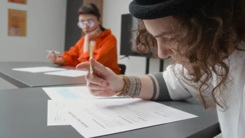 Tattooed Inmate Writing on Paper Doing Tasks during Class in Prison Stock Footage 328986301