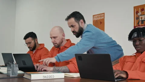 Tattooed Male Convict Working on Coding Project with Help from Teacher Video stock 314057417