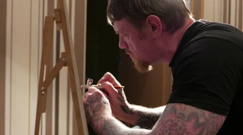 Tattooed man with airbrush in his hands. Stock Footage 59779216