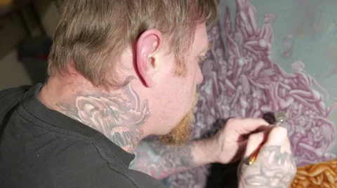 Tattooed man with airbrush in his hands. Видео 59779221