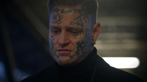 Tattooed man with intense expression in dramatic lighting, urbanstyle Stock Footage 280150462
