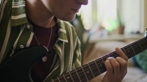 Tattooed Man with Nose Piercing Playing Guitar and Singing at Home Stock Footage 334796135