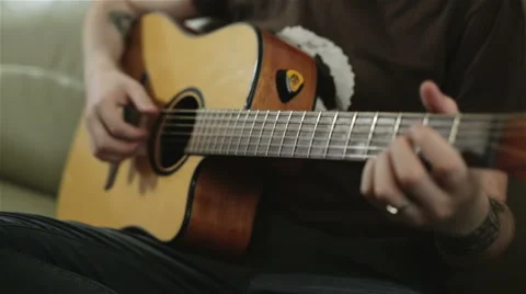 A tattooed man playing the guitar Stock Footage 61885717
