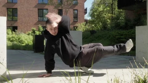 Tattooed man showcasing powerful breakdance moves in urban cityscape Stock Footage 283990333