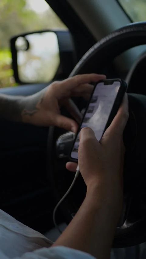 Tattooed man sitting in car using smartphone near steering wheel... Stock Footage 324632451