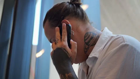 Tattooed Man Talking On Phone In Library, Representing... Stock Footage 334437183